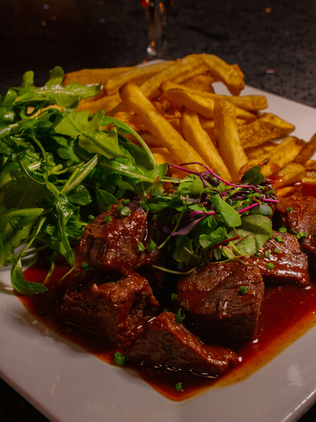 Steak and fries plated with a side salad